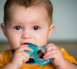 Baby chewing on teething ring toy